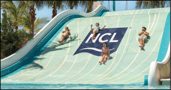 Three people in swimwear are sliding down a wide water slide with the NCL logo in the center, surrounded by palm trees and a pool at the bottom. Description generated by AI