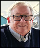 A man wearing a white shirt and black jacket. Description generated by AI